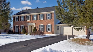 Red brick home with heated driveway in the winter